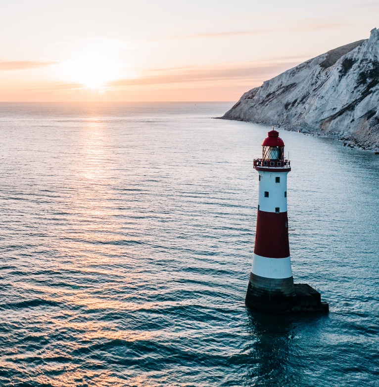 An image of a lighthouse with the sunset in the background