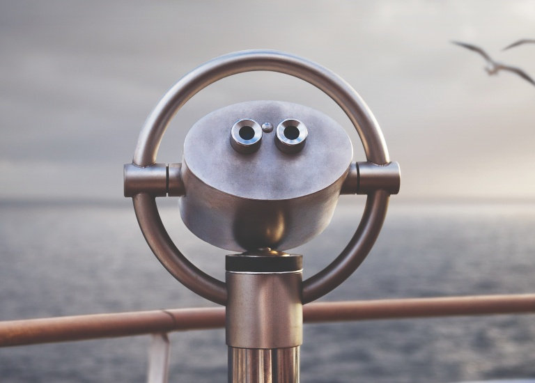 A pair of observation binoculars facing the sea