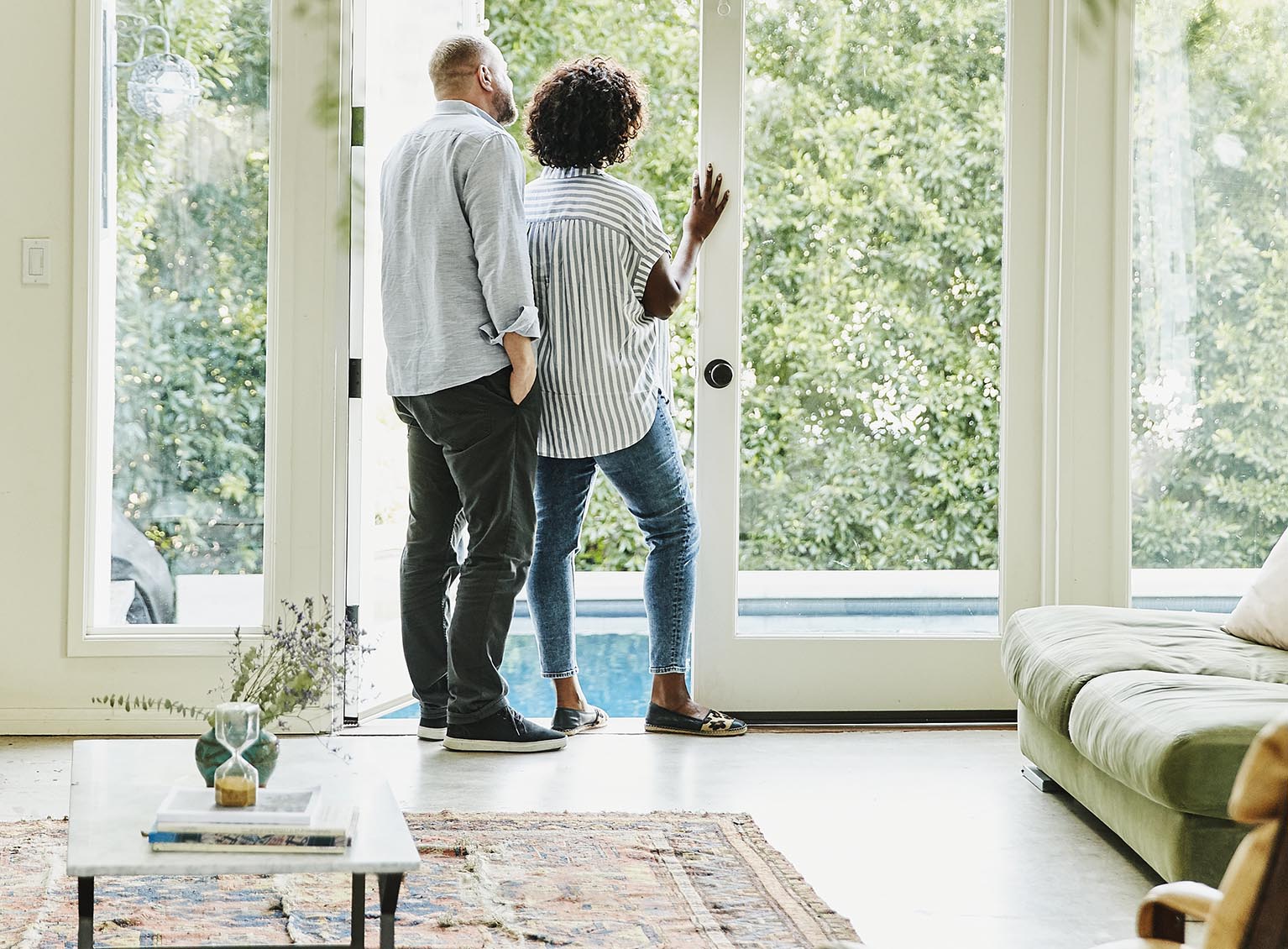 Couple standing looking out a window at home