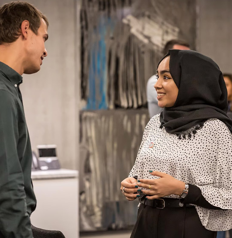 Two people chatting at an Investec programme event