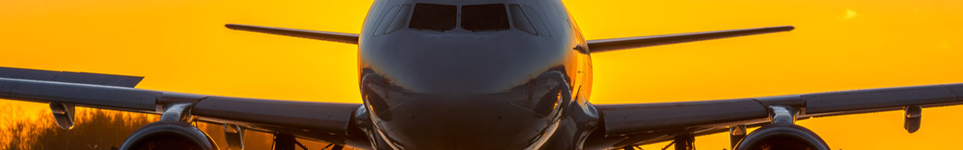 plane taking off with sunset behind