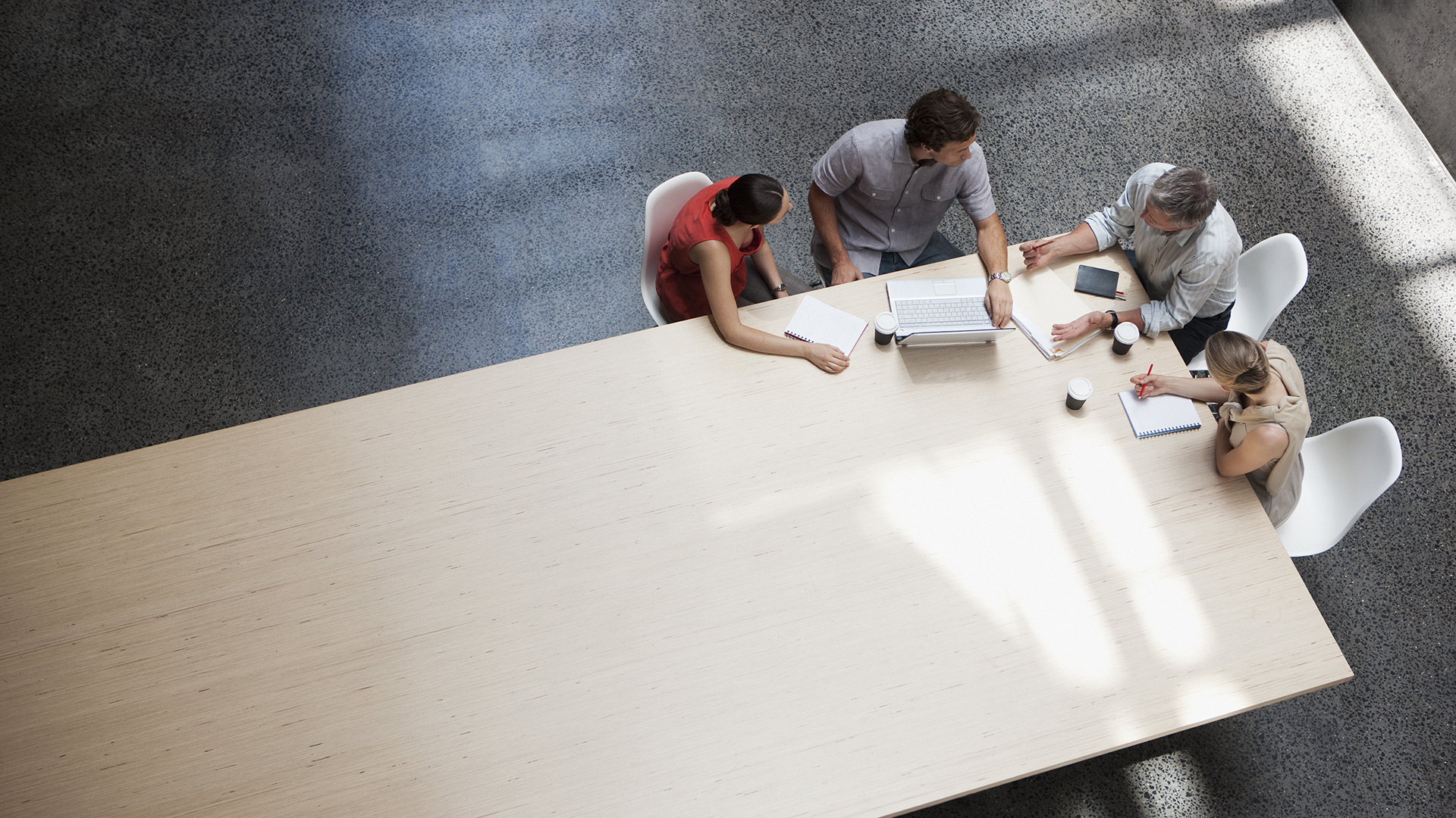 Four co-workers gather around a meeting table