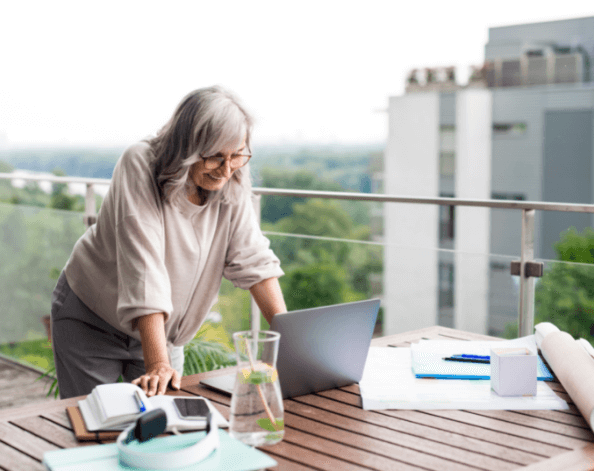 Lady on her balcony, looking at the laptop