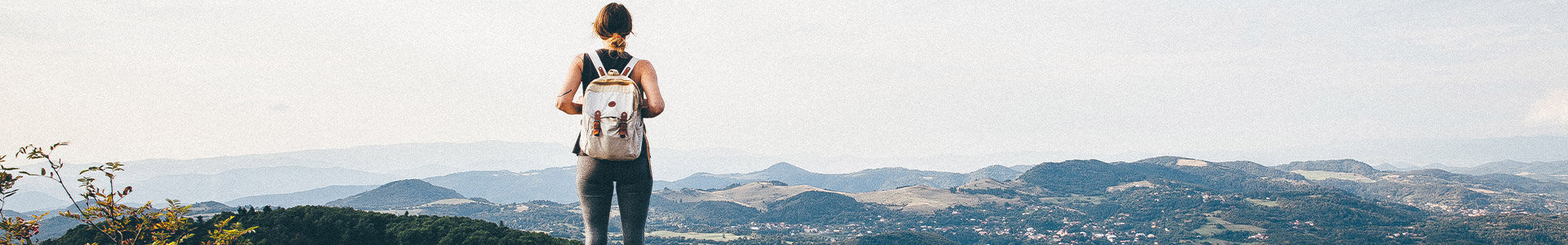 Female standing on top of cliff looking over edge