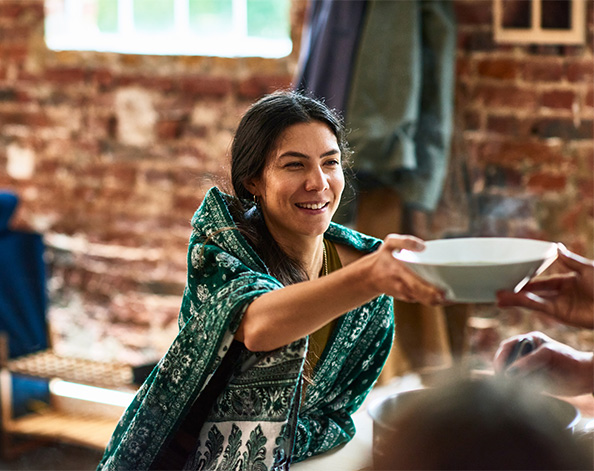 female accepting a bowl of soup