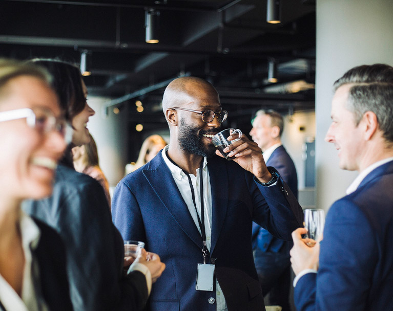 Entrepreneurs chatting at an event while drinking coffee