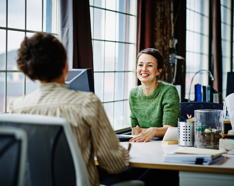 Two business owners chatting over a work desk