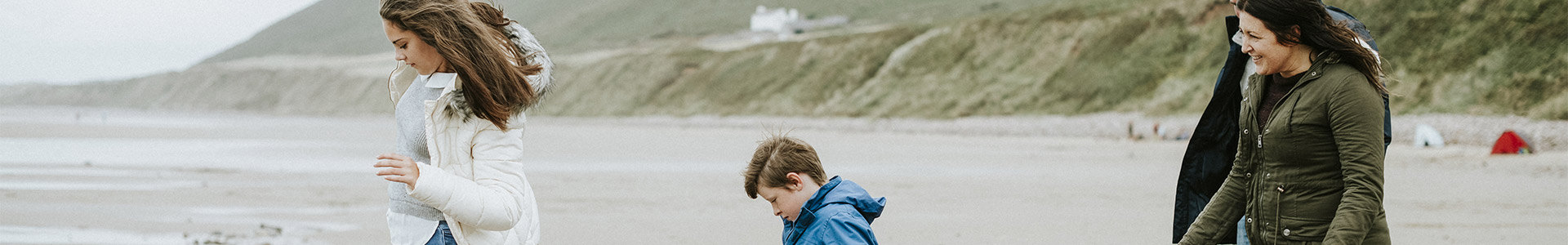 Family walking over stones on the beach