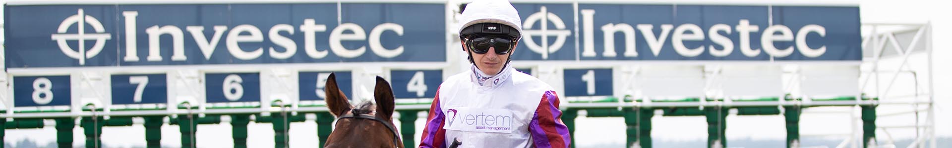 Jockey infront of the starting line with Investec signs displaying above