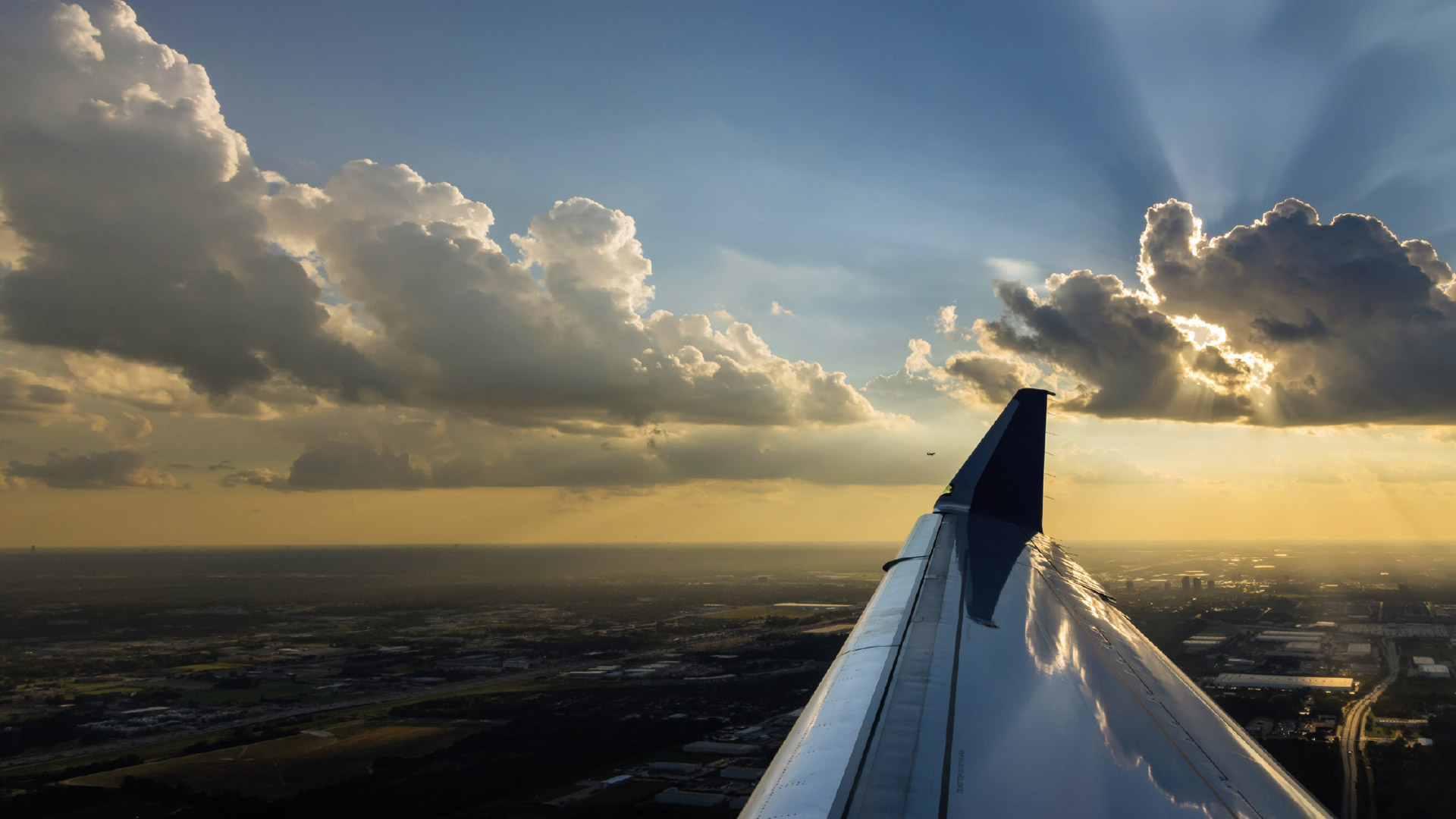 View out of plan window seeing sky and plane wing