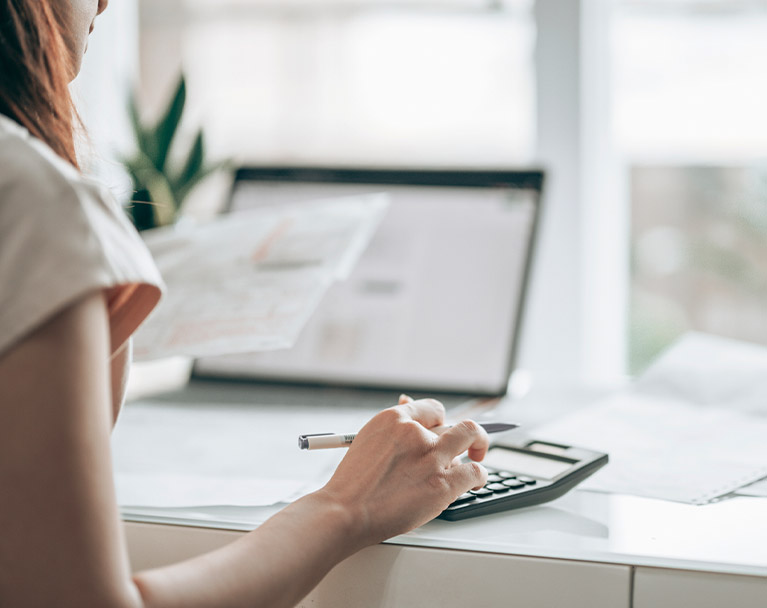 Female calculating household bills with calculator