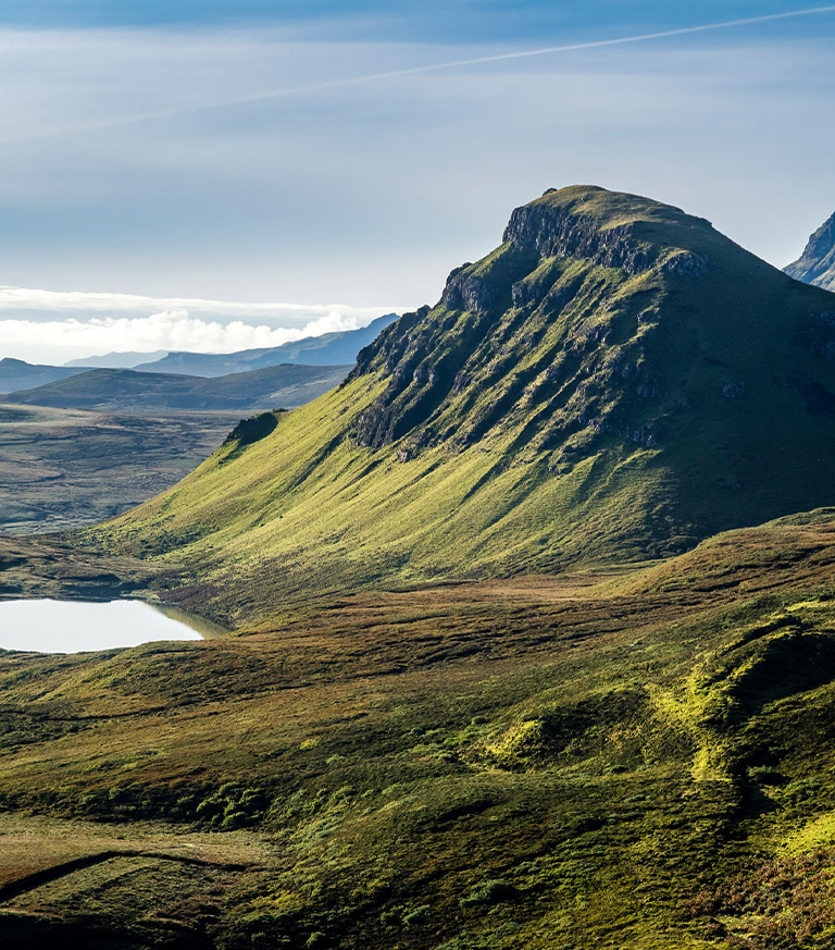 green mountain with lake below