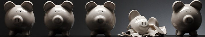 Row of piggy banks with one smashed to pieces