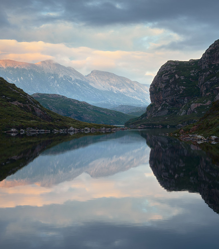 View across a lake towards mountains with relfection showing in the lake