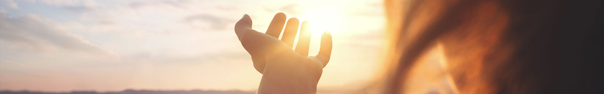 Woman with hand towards the sun