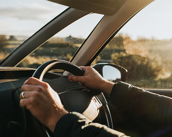 Male behind steering wheel driving his car