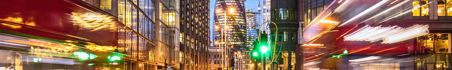 Red busses moving quickly through London City centre