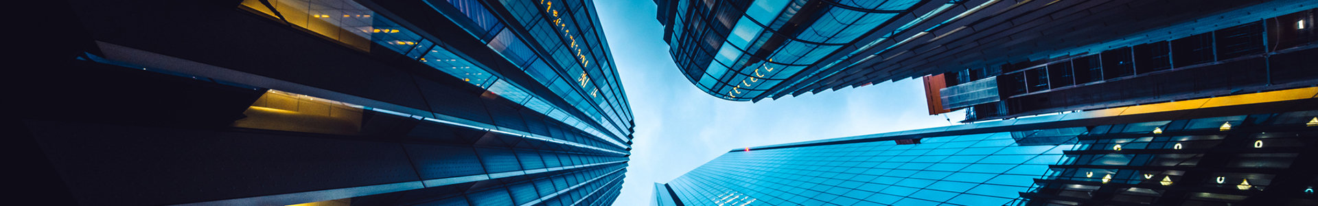 Looking up at three company tower buildings