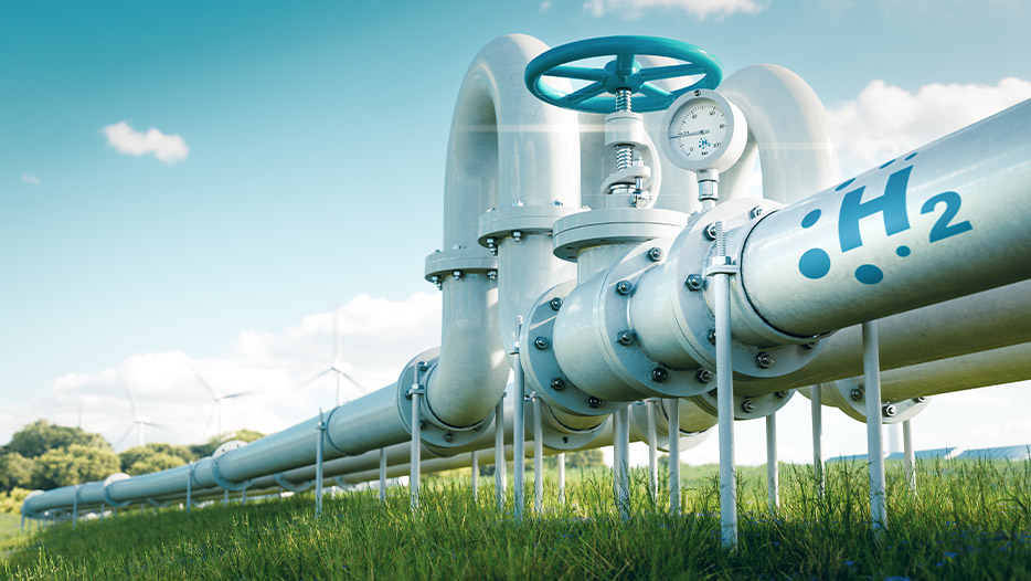 Pipes with wind turbines and solar panels in the background