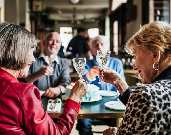 Two elderly couples enjoying a meal