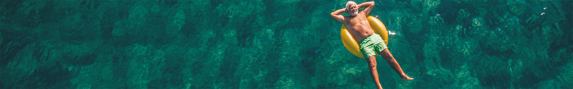 Investor looking back while relaxing on rubber ring in the sea
