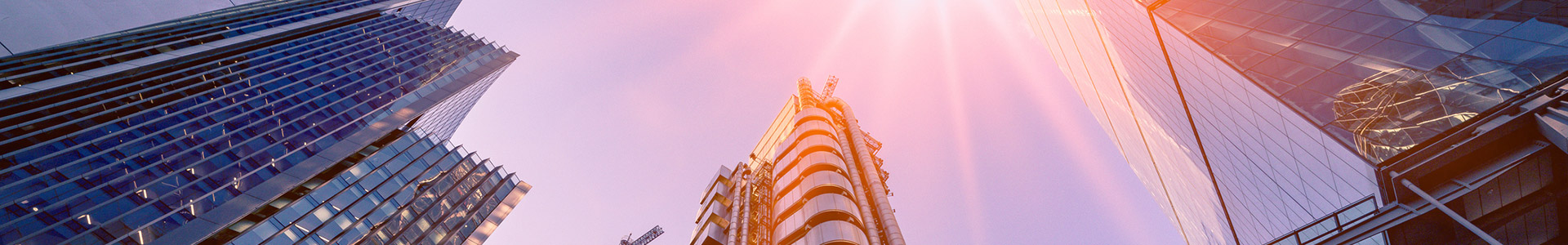Looking up at office buildings with sunset