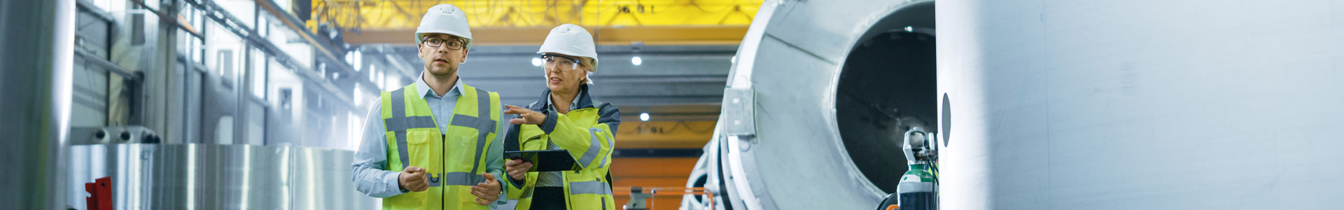 Testing, inspection and certification engineers walking through a manufacturing factory
