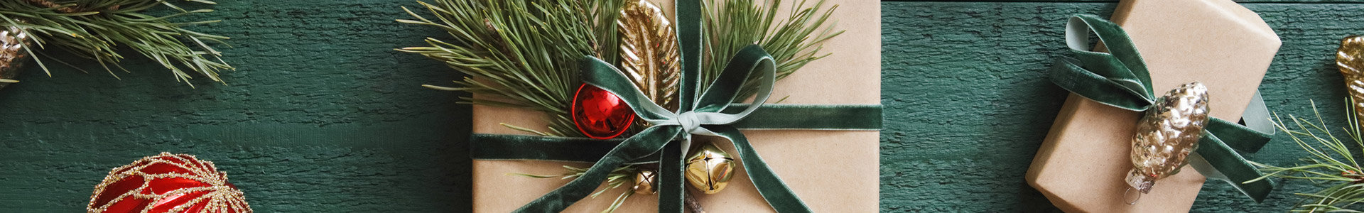 Christmas presents and decorations on a green wooden table top