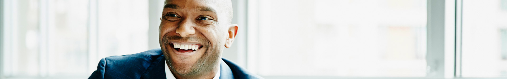 Male professional smiling at meeting table