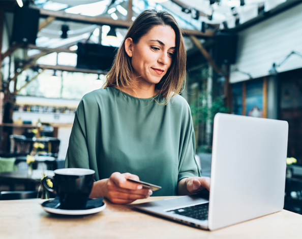 female buying something on laptop in coffess shop