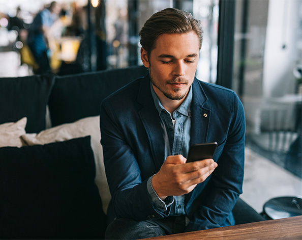 male checking his mobile phone in cafe