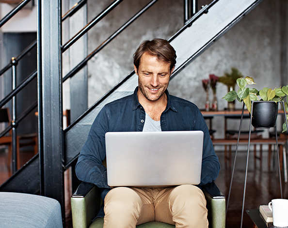 Man sitting with laptop on his knee