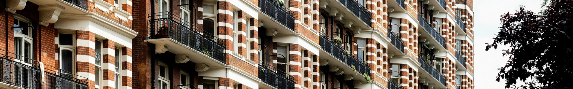 Close up of balconies on a bricked building containing flats
