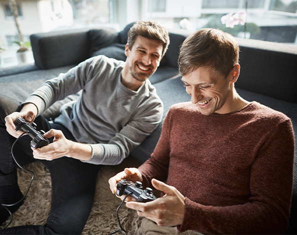 two young men playing computer games in their lounge