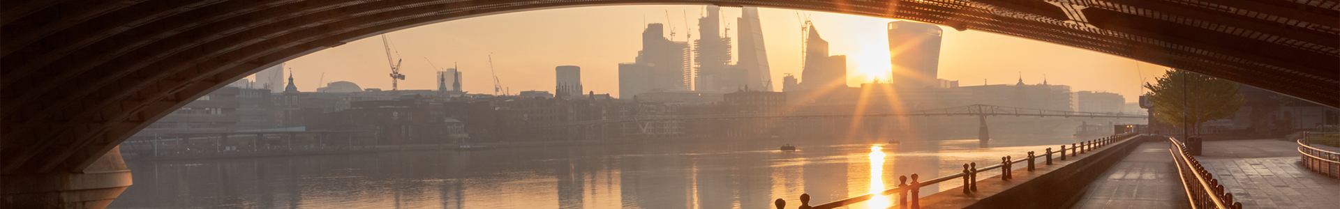 view of london city from under a bridge across the thames