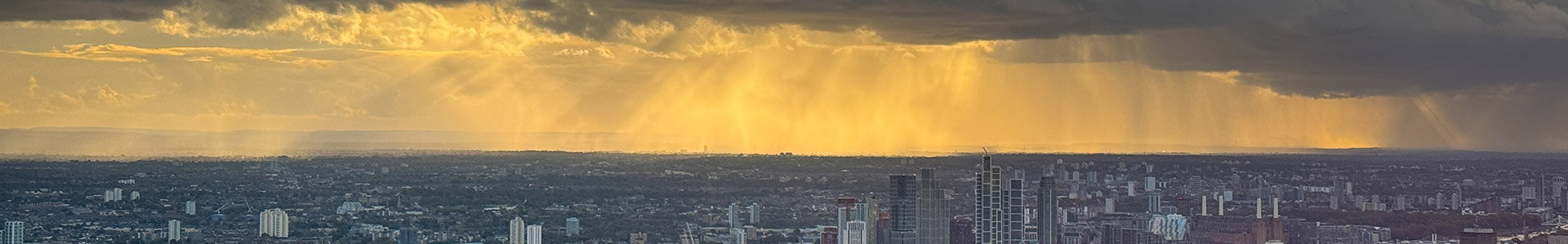 Sunlight breaking through dark clouds over London city