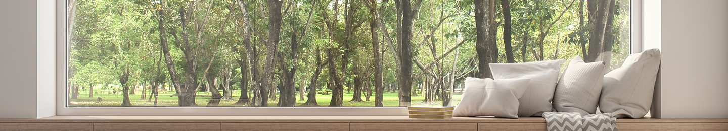 Cushionspile in a window seat overlloking a view of trees