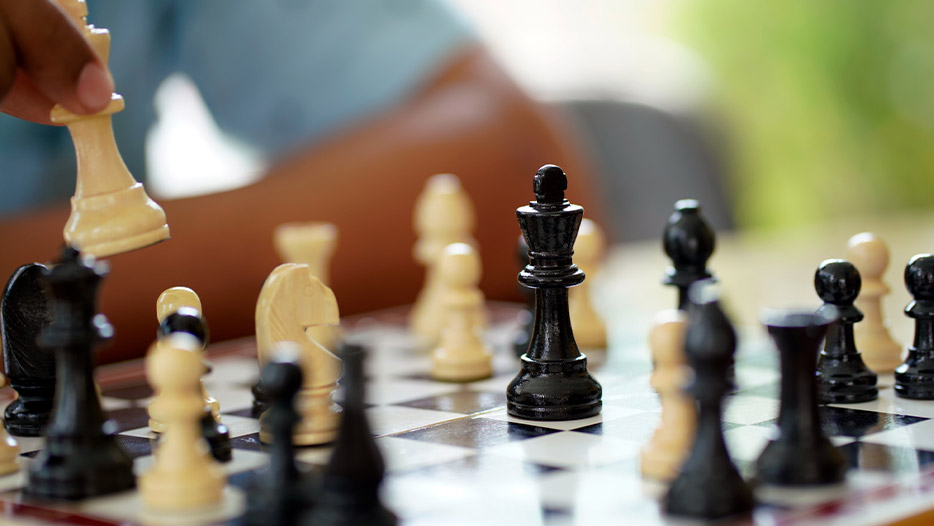 Someone moves a chess piece during a game of chess