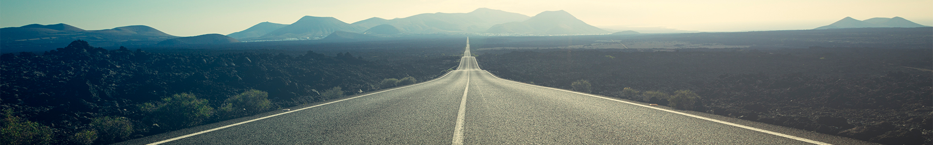 empty highway with mountains in the background