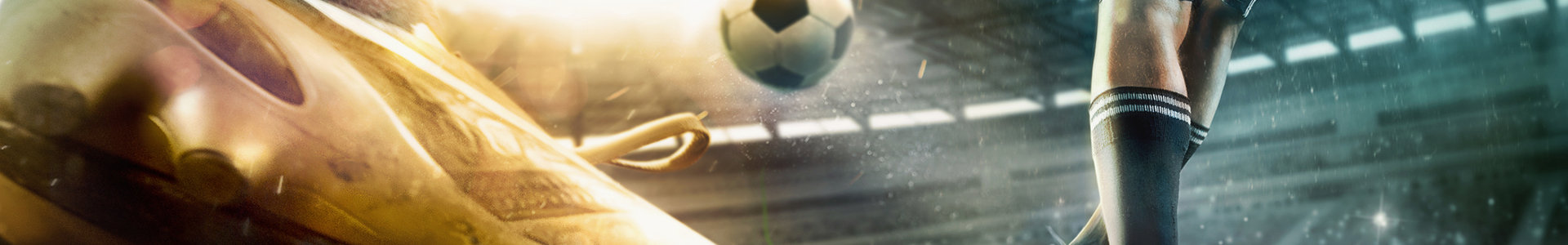 Close up of football boots with a football player in background kicking football in a stadium