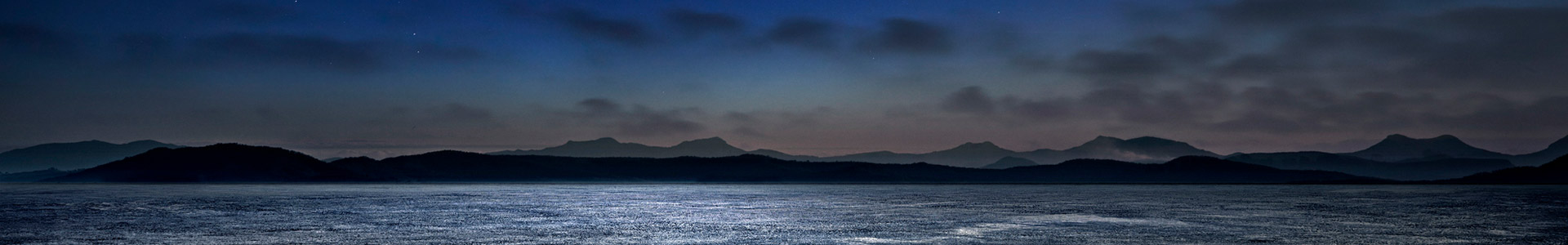 Full moon casting light over the ocean at night