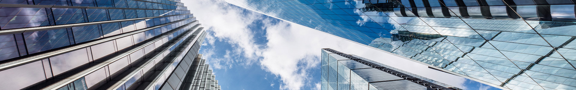Looking upwards at multiple glass business towers