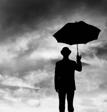 Silhouette of a man wearing a bowler hat and holding an umbrella