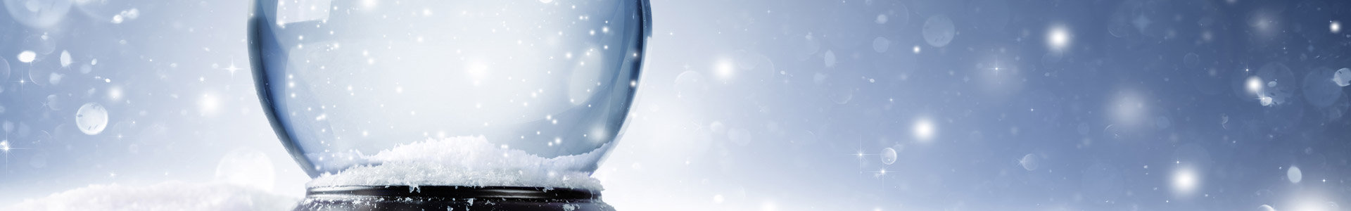 Snow globe sitting in snow with snow falling