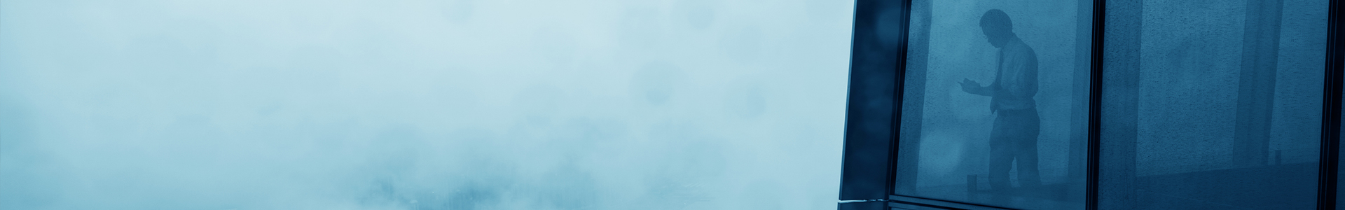 Man looking out of winow into heavy fog