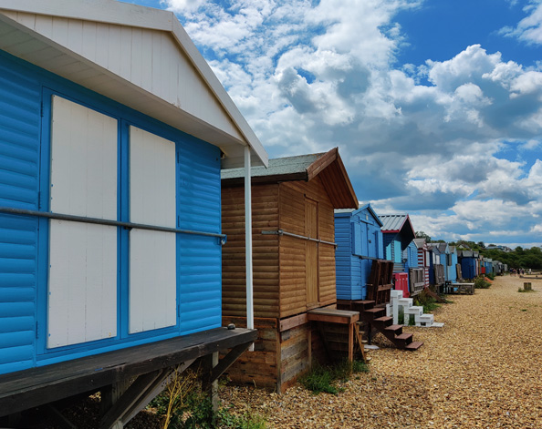 Perspective view of colourful beach huts stretching into the distance