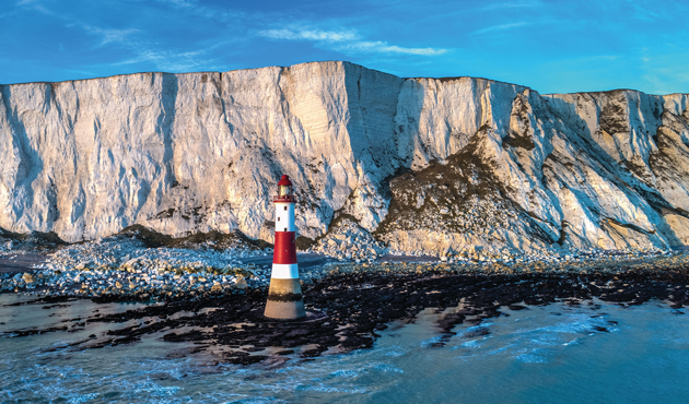 Red and white stripy lighthouse in front of chalk cliffs