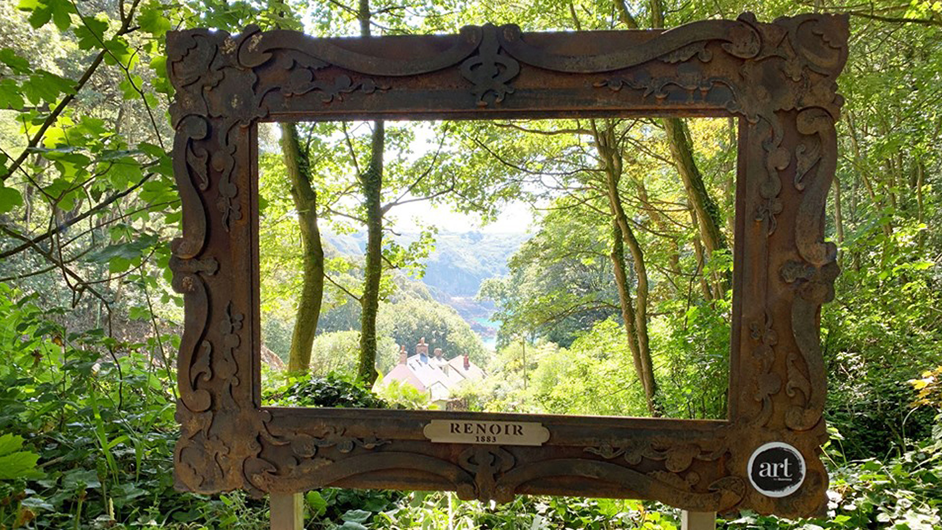 A wooden photo frame in the woods gives a view over a valley of trees