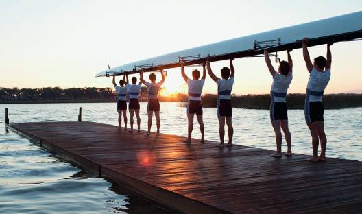 A rowing team loads their charity-backed boat into the water