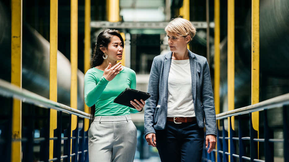 Business partners walking together in industrial unit